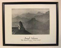 Framed black and white Ansel Adams photograph showing rock formations at Grand Canyon with printed text below image.