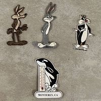 Lot includes three Hanna-Barbera character magnets and one whale-themed thermometer magnet from Monterey Whale Watch Center.