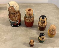 Six hand-painted wooden Russian Matryoshka dolls representing Soviet leaders arranged in descending size order.