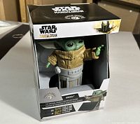 Boxed Grogu phone and controller holder showing Star Wars The Mandalorian branding and packaging indicating limited edition and cable compatibility.