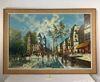 Full view of the framed 20th-century oil painting depicting a lively cityscape with prominent buildings, sky, trees, and crowds.