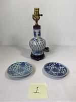 Table lamp and two matching porcelain plates together showing the set contents.