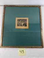 Front view of framed etching showing male portrait holding dagger.