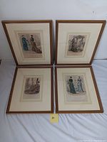 Photo showing all four framed Victorian fashion illustrations laid out on floor