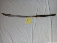 Full length photo of the Southeast Asian sword machattie showing curved blade and handle