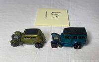 Two redline Hot Wheels cars side by side (green 32 Ford Vicky and blue 31 Ford Woody).
