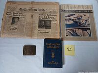 Overview photo showing the book, belt buckle, and several newspapers including Blizzard of 1978 and The Providence Visitor