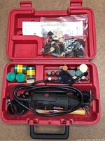 Complete red Craftsman carrying case with Dremel rotary tool and assortment of rotary bit attachments, sanding bands, polishing discs and drill bits organized in compartments.