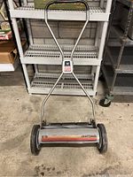 Full view of Craftsman manual push mower showing metal framed body, black plastic wheels, and red branding.
