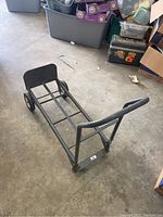 Photo showing hand cart in dolly mode with four wheels on floor and metal frame.