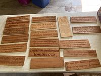 18 wooden carved quote signs laid out on a flat surface, showing all items in the lot with visible engraved text