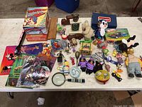 Overview photo showing assortment of toys, magazines, model kits, and figurines on floor.