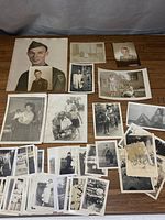 Overview of all photographs in the lot showing old portraits, family, children, and candid images scattered on a surface