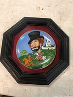 Framed decorative plate showing Red Skelton clown on a horse with dragon and castle background.