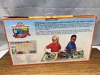 Back of the Thomas the Tank Engine & Friends box with detailed description and imagery showing children playing with the set and full parts list.