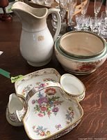 Three white ceramic and bone china pieces including floral decorated Hammersley cream, sugar, and tray set, large decorative biscuit bowl with metal rim, and plain unmarked white ceramic pitcher showing signs of crazing.