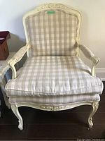 Front view of beige checkered upholstered wood armchair