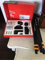 Set of Asahi Pentax Auto 110 close-up lenses and accessories in original red tray with Pentax branding; includes lens rings, caps, and cases.