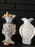 Front view of two vases: the floral PF Rolo Limoges vase with gold trim and the white embossed Kaiser vase.