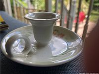 Top-down view showing the floral hand-painted decoration and the candle socket with connected handle.