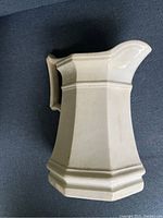 Side view of the antique French ironstone jug, showing its octagonal shape and handle.