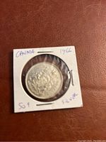 Obverse side of 1966 Canadian half dollar coin showing sailing ship and markings in protective holder.