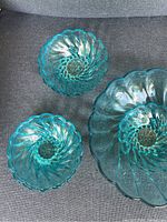 Top view of two small aqua blue depression glass bowls showing spiral swirl pattern and scalloped edges.