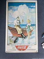 Full view of Coca Cola anniversary sign showing the artwork and logo clearly.