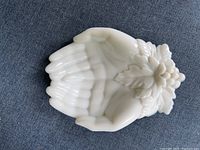 Full top view of milk glass soap dish shaped like hands with grape leaf and grape cluster decoration.