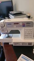 Front view of Brother computerized sewing machine showing the LCD display, stitch selection buttons, and stitch pattern guide panel.