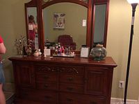 Front view of dresser with attached triple mirrors and displayed items on top