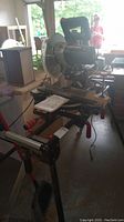 Stand assembled with attached roller extensions and saw placed on top