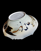 View of base showing artist signature engraved on white ceramic.