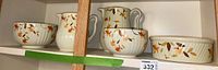 Photo showing the complete set of Halls kitchenware including pitchers, bowls, and baking dish with autumn leaf patterns.