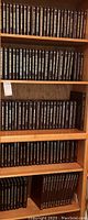 Bookshelf showing multiple shelves filled with black leather-bound volumes