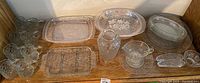 Wide shot showing all various glassware items including glasses, serving trays, vase, creamer, and small dishes, all with Princess House Fantasia etching.