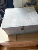 Aluminum lock box with latch closure, shows signs of wear