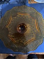 Top view of the amber depression glass cake stand showing detailed pressed geometric and fan patterns.