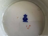 Close-up photo of the mark on bottom showing Royal Crown Derby hallmark and Imari pattern identifier, stamped in blue with crown and red script numbers