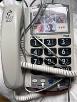 Photo of Clarity P300 telephone showing the handset, large buttons, photo speed dials, and volume control buttons.