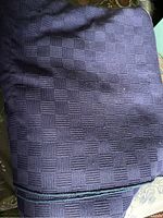 Close-up of large blue textured tablecloth with a checkered pattern