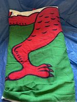 Photo of a folded large Welsh flag showing a red dragon design over green and white sections.