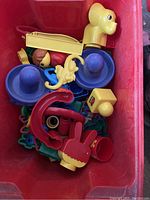 Top view of bin with Fisher-Price dog pull toy and assorted colored marble run pieces and Duplo figures