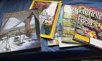 Photo showing a collection of magazines and a Safari Style book, titles visible include Mother Earth News, National Geographic, and Sunset.