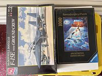 Photo showing the sealed McDonnell Douglas F-15E with Ground Crew model kit box and Ravensburger 1000-piece puzzle in original packaging