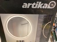 Front of box showing illuminated round mirror, Artika logo and model name