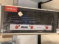Full view of original box showing Camp Chef branding and three-burner flat top cooking system image.