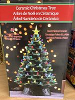 Box front showing ceramic Christmas tree image and product features including hand painted ceramic and over 90 bulbs in multiple colors.