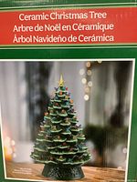 Box showing a ceramic Christmas tree with colorful bulbs and a star on top, labeled in three languages.