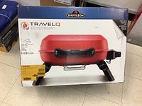 Front of sealed original box showing red Napoleon TravelQ portable gas grill